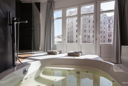 Foto del jacuzzi junto a la ventana y con vistas a la ciudad de Madrid en la Habitación Doble Premium del hotel Vitium Urban Suites